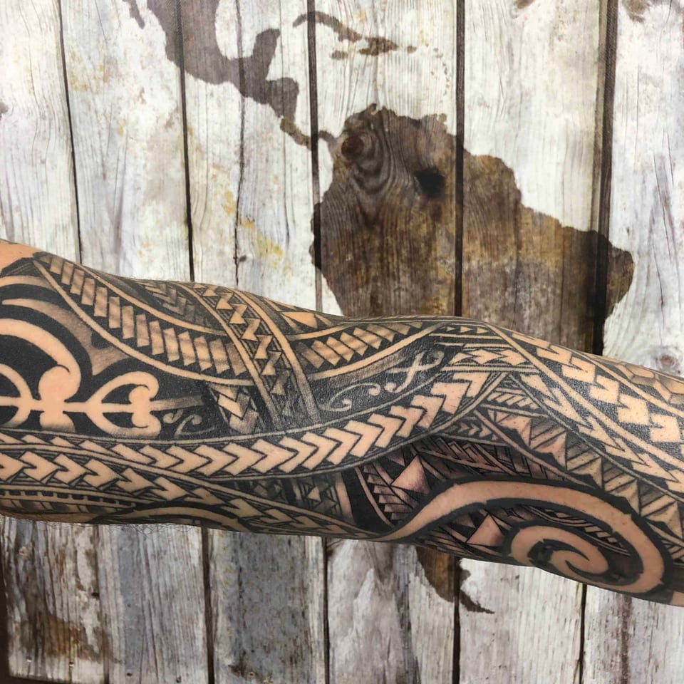 Polynesian tribal pattern around the elbow of an outstretched arm, tattooed by Seth Reynolds