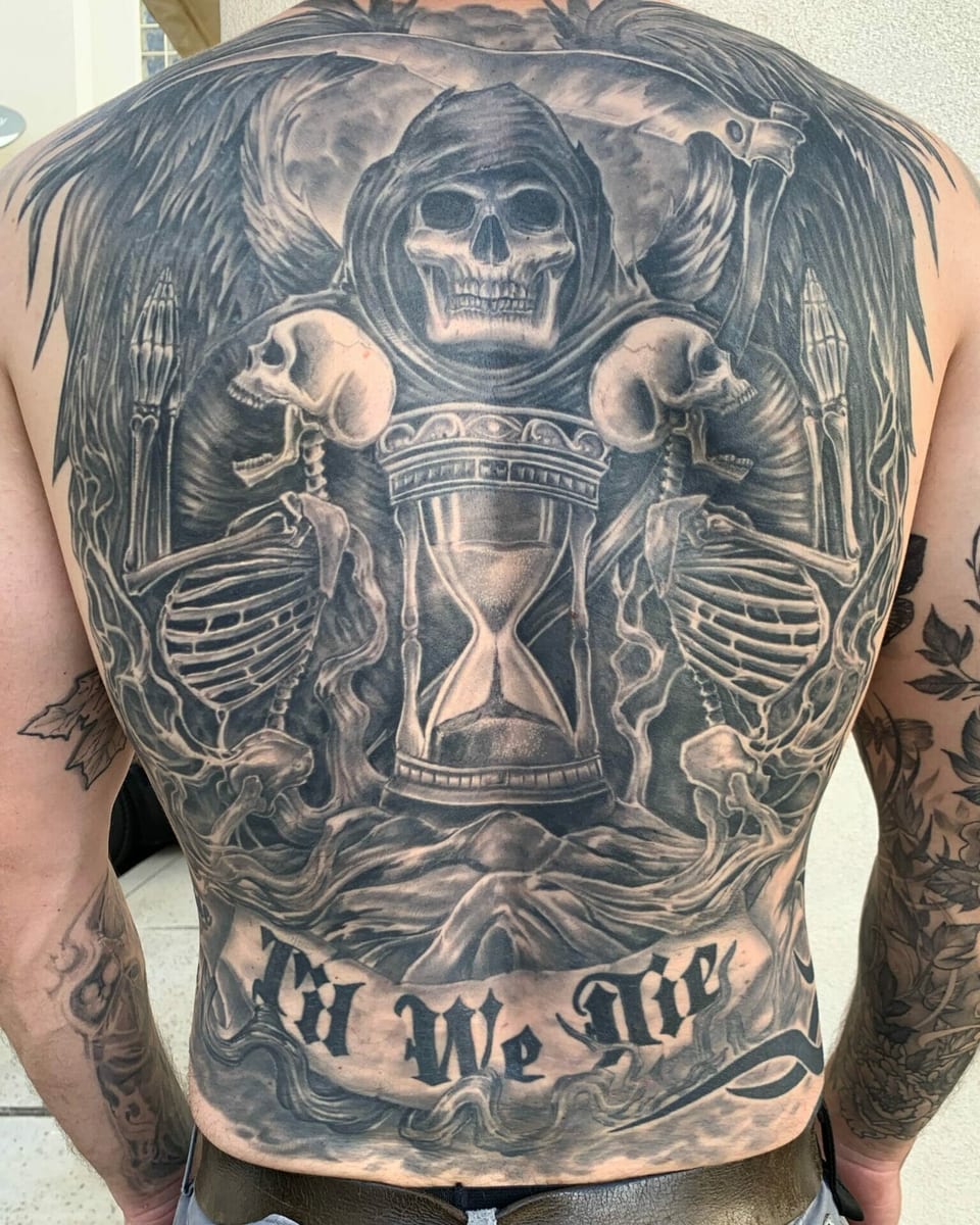 Black and grey realism back tattoo combines a grim reaper, skeletons and an hourglass.